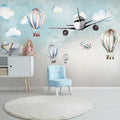Aviation wallpaper bringing life to a bright nursery with hot air balloons and airplanes floating above the crib