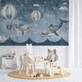 Whale and balloon wallpaper mural in a modern nursery with white furniture and soft lighting