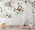 Koala wallpaper mural styled in a bright nursery with white furniture and natural decor elements