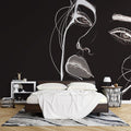 Line art portrait wallpaper creating dramatic impact in a modern living room with minimalist furniture