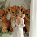 Lion Cubs Wallpaper in bright modern nursery, showing three playful cubs among tropical leaves