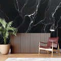 Black marble wallpaper creating dramatic impact in modern living room with white furniture