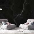 Black marble wallpaper with white veins creating a dramatic effect in a modern living room with high ceilings