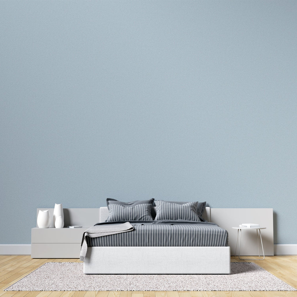 Minimalist dining room with soft blue wallpaper creating airy atmosphere