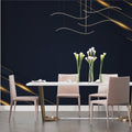 Navy and gold geometric wallpaper in modern living room with grey sofa and natural light