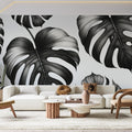 Modern dining room with Black and White Monstera Leaf Wallpaper creating dramatic contrast against minimalist furniture
