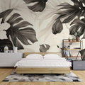 Black and white Monstera leaf wallpaper creating a stunning focal point in a modern living room with natural light