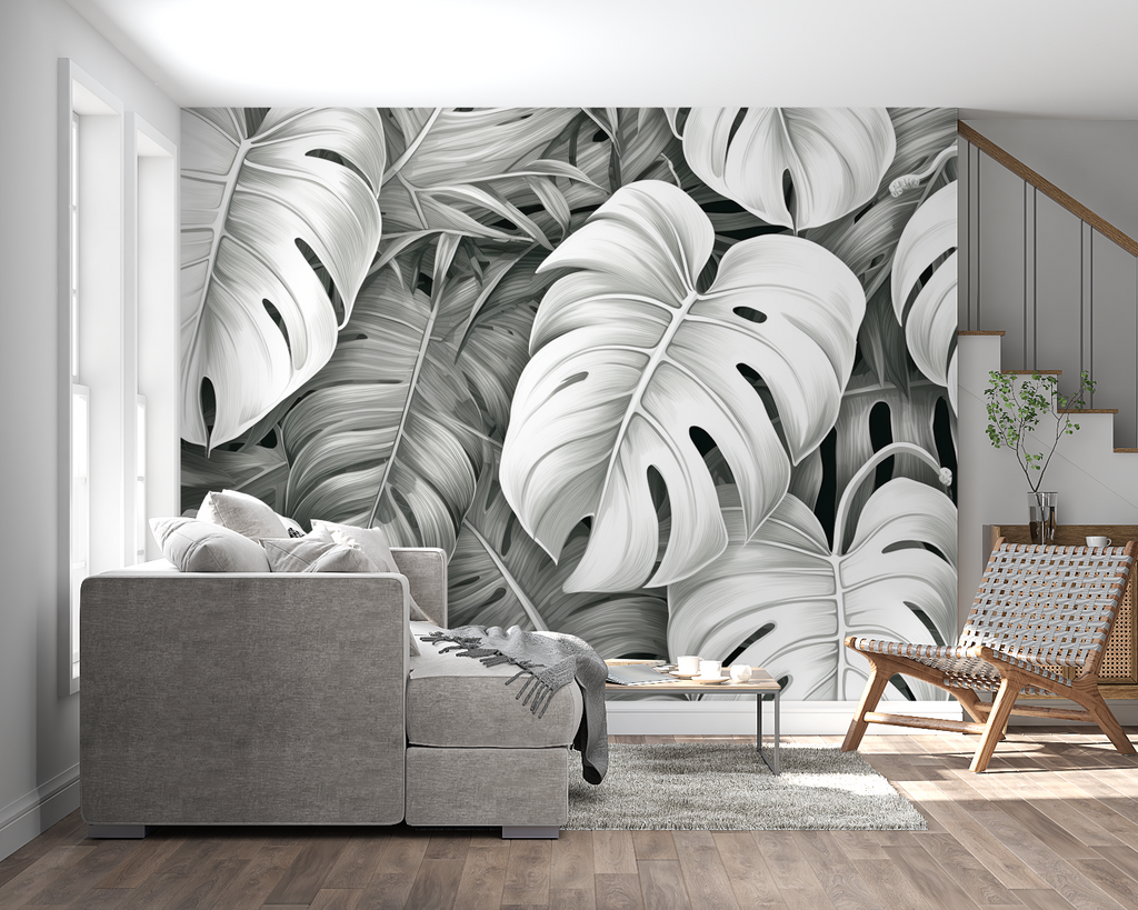 Black and white Monstera leaf wallpaper creating drama in modern living room with minimal furniture