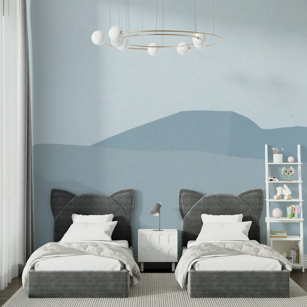 Blue mountain wall mural in child's nursery with simple furniture