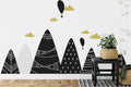 Modern mountain wallpaper with black and gold design styled in a bright Scandinavian living room with minimal furniture