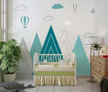 Mountain nursery wallpaper with hot air balloons shown in a bright modern nursery with white furniture