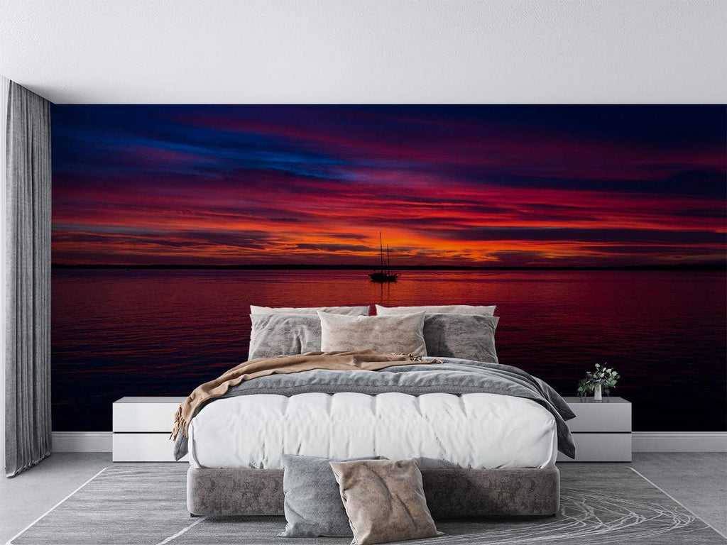 Dramatic red sunset seascape wallpaper as a stunning backdrop in a master bedroom suite