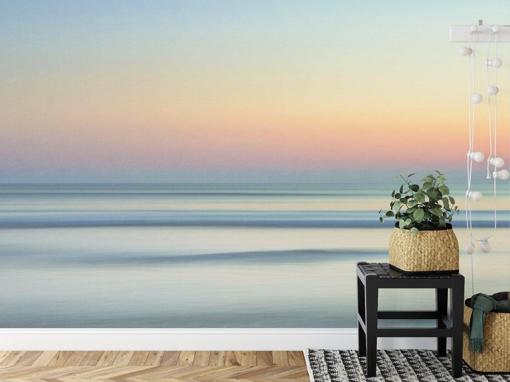 Ocean sunset wallpaper creating a calm atmosphere in a modern living room with minimal furniture