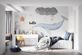 Ocean theme wallpaper with whale design shown in a bright nursery with white furniture