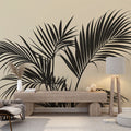 Palm leaf wallpaper creating a modern tropical atmosphere in a minimalist living room with beige sofa and black accents