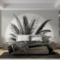 Black and white palm leaf wallpaper creating dramatic contrast in a modern living room with minimalist furniture