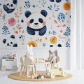 Panda wallpaper mural in bright nursery with white furniture showing watercolor pandas and orange flowers