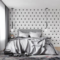 Modern black and white polka dot wallpaper in a minimalist living room setting