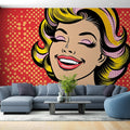 Pop art portrait wallpaper creating a bold statement in a modern living room with white furniture and minimal decor