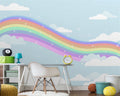 Rainbow wallpaper mural in bright nursery with white furniture showing soft pastel colors and dreamy clouds