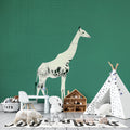 Modern Safari Wallpaper with white giraffe silhouette styled in a bright Scandinavian living room setting