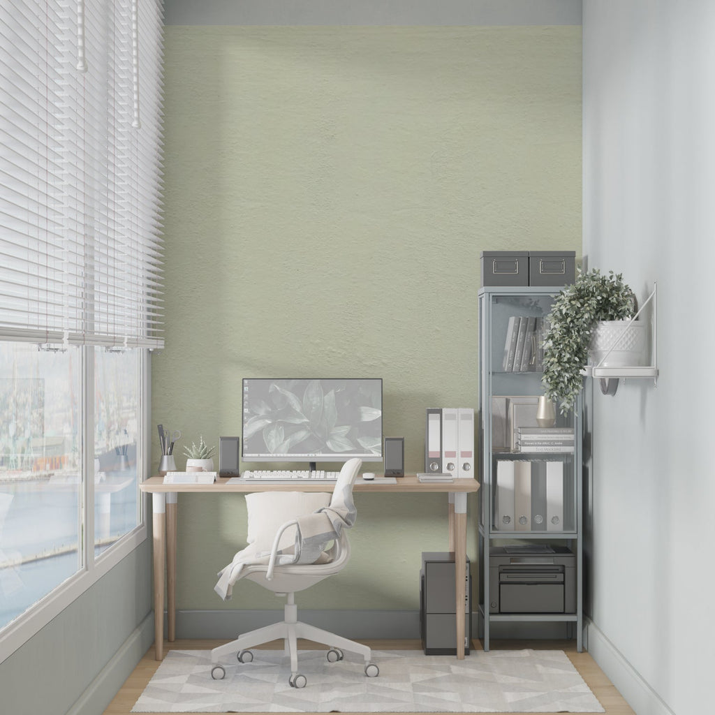 Home office space with sage green minimalist wallpaper creating a focused environment