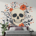 Gothic skull wallpaper with orange flowers creating dramatic impact in modern living room with grey sofa and minimal decor