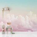 Pink cloud wallpaper creating a dreamy atmosphere in a modern nursery with white furniture