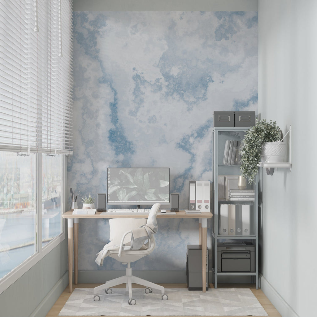 Watercolor sky wallpaper brightening a minimalist bedroom with soft blue tones