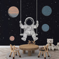 Space themed wallpaper with swinging astronaut brings wonder to a modern kids bedroom, perfect for dreamy bedtime stories