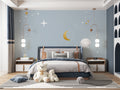 Space theme wallpaper with moon and stars creating a cozy atmosphere in a modern nursery