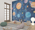 Space wallpaper mural creating a magical atmosphere in a modern kids bedroom with rocket-themed decor