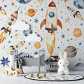 Space theme wallpaper in modern nursery showing watercolor rockets and planets creating a dreamy atmosphere