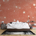 Terracotta star wallpaper in a cozy bedroom creating a warm, dreamy atmosphere