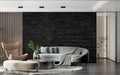 Dark stone textured wallpaper in modern living room with grey sofa and minimal decor