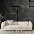 Modern black stone block wallpaper creating depth in a minimalist living room with ambient lighting