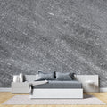 Modern grey stone effect wallpaper in contemporary living room with natural light highlighting metallic details
