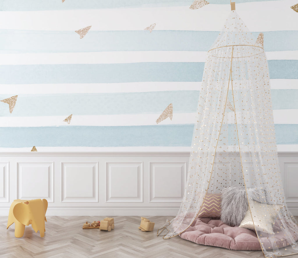 Blue and white striped wallpaper with gold planes creating a calm atmosphere in a baby's room