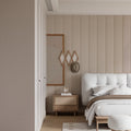 Modern striped wallpaper in bright living room with minimal furniture showing vertical beige pattern