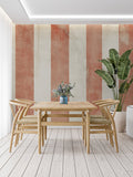 Modern dining room featuring vertical striped wallpaper in warm terracotta and cream tones