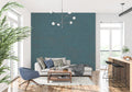 Teal textured wallpaper creating depth in a modern living room with natural light highlighting the organic pattern
