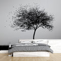 Black and white tree mural wallpaper creating a striking focal point in a modern minimalist living room