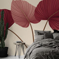 Burgundy and pink tropical leaf wallpaper creating a cozy atmosphere in a modern living room with natural light