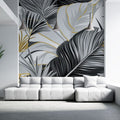 Tropical palm leaves wallpaper in black and gold creating drama in a modern living room with high ceilings