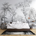 Black and white tropical wallpaper creating depth in modern living room with grey sofa