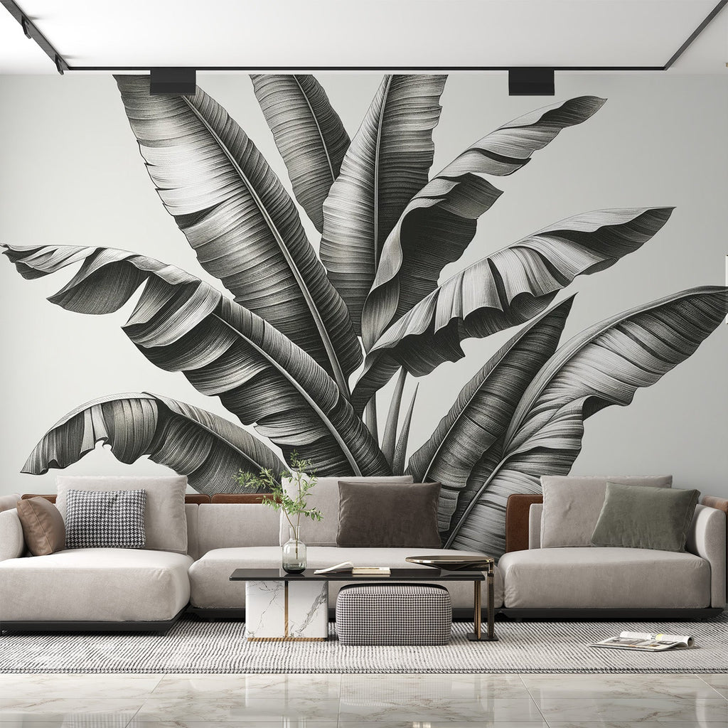 Black and white tropical leaf mural wallpaper creating depth in a modern living room with clean furniture and natural light