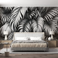 Black and white Monstera leaf wallpaper creating dramatic contrast in modern living room with minimalist furniture