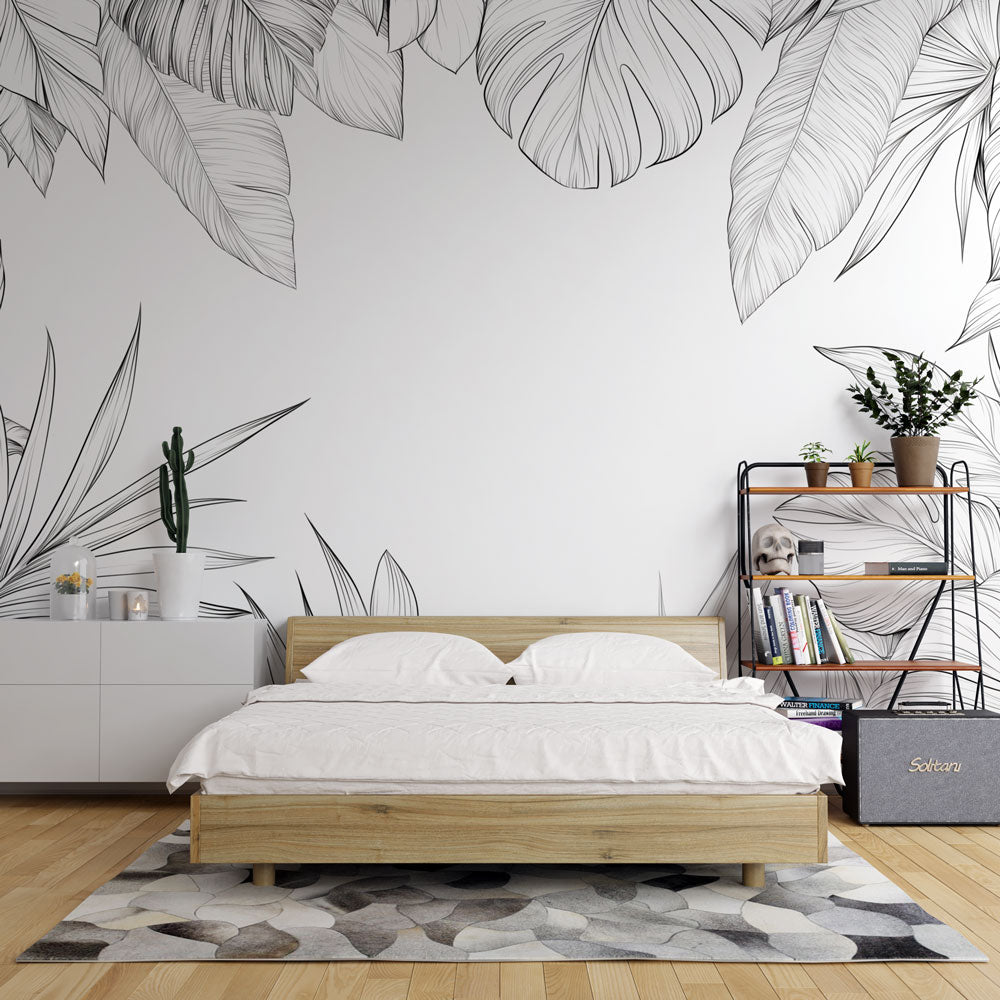 Black and white Monstera leaf wallpaper creating a stunning accent wall in a modern minimalist living room