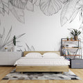 Black and white Monstera leaf wallpaper creating a stunning accent wall in a modern minimalist living room