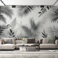 Black and white tropical leaf wallpaper creating a modern statement wall in a bright living room with minimal furniture